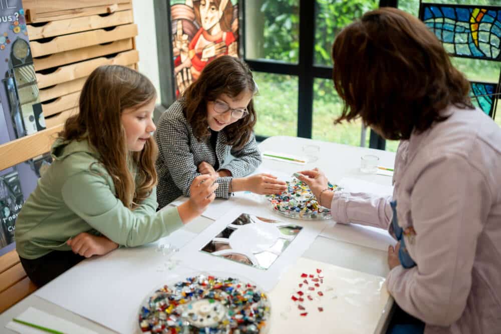 Famille créant son propre miroir avec des morceaux de verre de toutes les couleurs