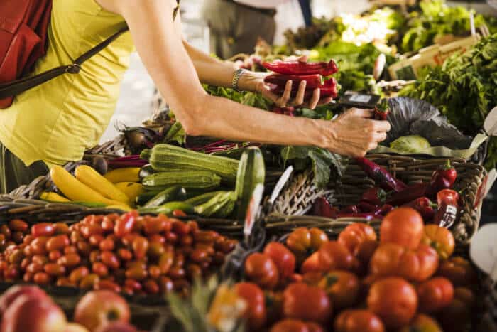 man choosing vegetable from vegetable stall supermarket - Tourisme Vienne